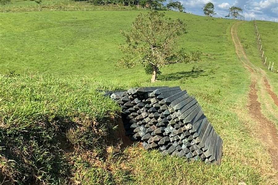 Estantillos apilados junto a un camino de potrero tras la descarga.